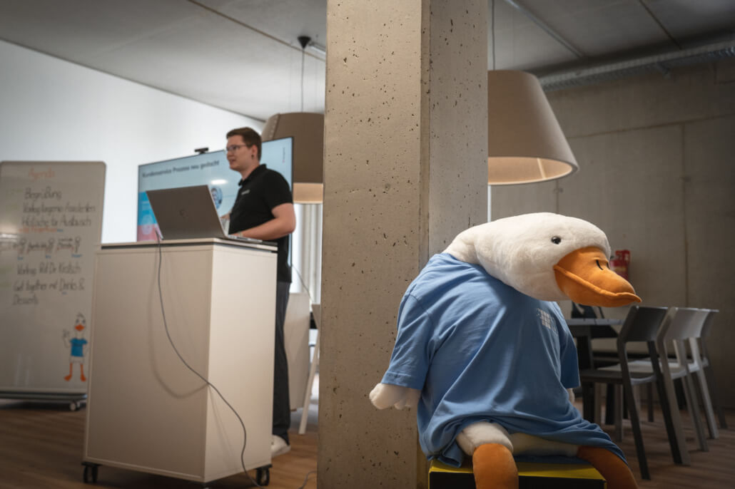 Jan präsentiert die targenio Assistenten-Plattform auf dem eigenen Event des Nürnberg Digital Festivals 2025. Im Vordergrund das Maskottchen targoosy